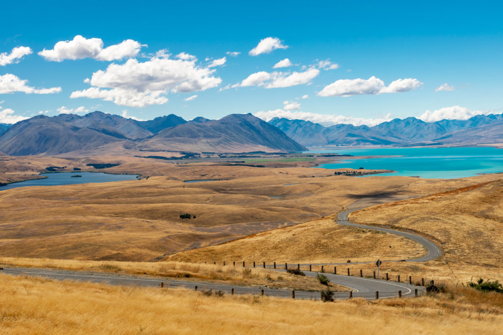 The rolling golden hills and bright blue waters of Lake Tekapo